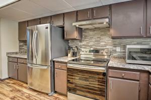 a kitchen with stainless steel appliances and wooden cabinets at Lakefront Fairbanks Unit, 1 Mile to Pioneer Park! in Fairbanks