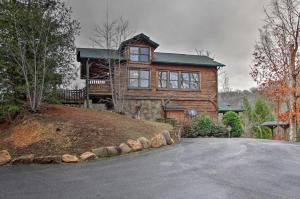 a large wooden house on a hill with a driveway at Sevierville Cabin with Hot Tub and Large Deck! in McCookville