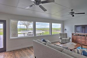 a living room with a couch and a tv and a table at Pickleball Court and Pool Schulenburg Farmhouse in Schulenburg