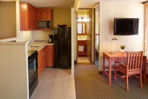 a kitchen with a table and a black refrigerator at Pacific Monarch Hotel in Honolulu