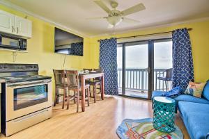 een woonkamer met een blauwe bank en een keuken met uitzicht bij Corpus Christi Beachfront Condo with Pool Access! in Corpus Christi