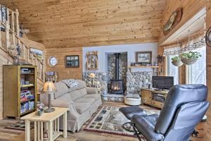 una sala de estar con sofá y TV en una cabaña en Cozy Cabin on 10 Acres, Walk to Chippewa River! en Weirgor