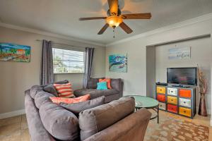 a living room with a couch and a ceiling fan at Condo-Walk to Daytona Beach, 6 Mi to Speedway in Daytona Beach
