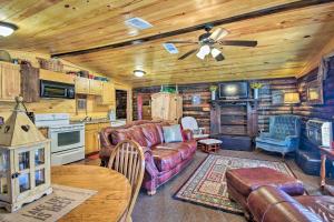 a living room with a couch and a tv in a cabin at Arkansas Log Cabin Rental Near Lake Greeson! in Mount Moriah
