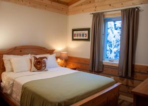 Schlafzimmer mit einem Bett und einem Fenster in der Unterkunft Denali Wild Stay - Moose Cabin, Free Wifi, 2 private bedrooms, sleep 6 in Healy