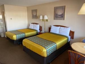 CorningParkview Motel的有两张床和一张桌子的酒店房间
