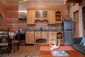 cocina con armarios de madera y mesa en Denali Wild Stay - Redfox Cabin, Free Wifi, private, sleep 6, en Healy