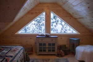 a bedroom with a large window in a log cabin at Denali Wild Stay - Redfox Cabin, Free Wifi, private, sleep 6 in Healy