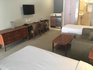 a hotel room with two beds and a tv at Shangri-La Gardens in Brisbane