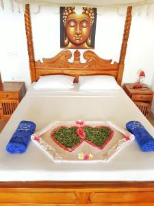 a bed with a heart shaped cake on it at Jemeluk Beach Bungalows in Amed