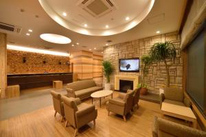 a waiting room with chairs and a fireplace at Dormy Inn Sapporo Annex in Sapporo