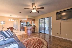 uma sala de estar com um sofá e uma ventoinha de tecto em Sunny Florida Escape with Patio Near Disney World! em Deltona