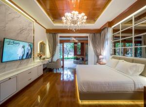 Un dormitorio con una gran cama blanca y una lámpara de araña. en Modern Love Villa en Chiang Mai