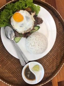 a plate of food with a fried egg and rice at Por Chey in Battambang