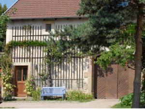 un banco azul sentado frente a una casa en Gite Mentrel en Champ-le-Duc