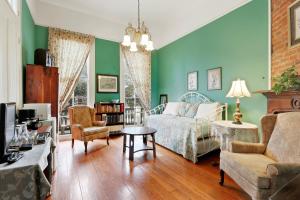 um quarto com paredes verdes, uma cama e uma mesa em Garden District Bed and Breakfast em Nova Orleans