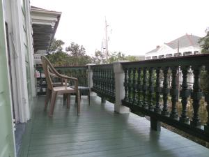 a wooden balcony with a chair on a house at Garden District Bed and Breakfast in New Orleans