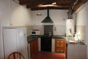 a kitchen with a white refrigerator and a stove at Cabaña en Olivar Centenario Agroecológico Tutuna in Pocito