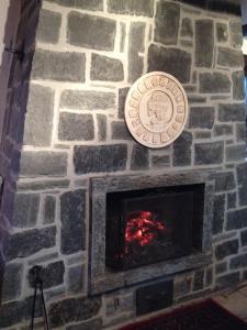 a stone fireplace with a plaque on it at Casa delle Befane in Aurigeno