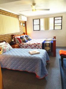 a bedroom with a bed, chair, desk and a lamp at Gowrie Agapanthus in Singleton