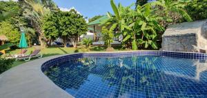 a swimming pool in front of a house at Green Canyon Resort in Lamai