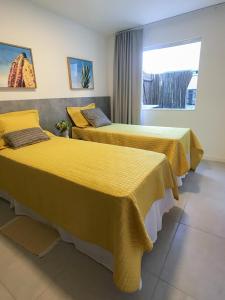 A bed or beds in a room at Porto Smeralda Guarajuba 100m praia