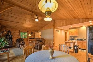 a living room with a table and a kitchen at Cozy Amish Country Cabin on Shipshewana Lake! in Shipshewana