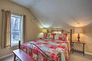 a bedroom with a bed and a window at Fife Lake Farmhouse with Fire Pit By Manistee River! in Fife Lake
