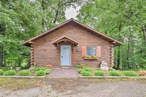 a small log cabin with a blue door at Cozy Amish Country Cabin on Shipshewana Lake! in Shipshewana