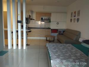 a living room with a couch and a kitchen at hasanah evo studio suites in Kampong Sungai Ramal Dalam
