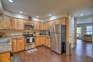 a kitchen with wooden cabinets and a stainless steel refrigerator at Lake Placid Home with Grill 9 Mi to Whiteface Mtn! in Lake Placid