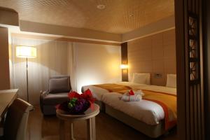 a hotel room with a bed and a chair at Daiwa Roynet Hotel Naha Kokusaidori in Naha