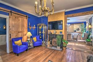 ein Wohnzimmer mit blauen Wänden und einem Kronleuchter in der Unterkunft Vicksburg Home with 3 Porches, Walk to Downtown in Vicksburg