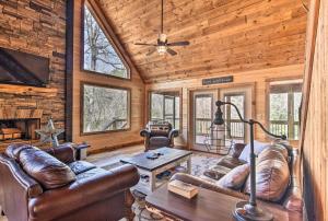 a living room with leather furniture and a fireplace at Modern Murphy Cabin with Nottely River Views! in Murphy