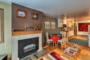 a living room with a fireplace and a table at Central Anchorage Condo, Walk to Town and Coast! in Anchorage