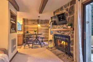 a living room with a stone fireplace and a table at Rustic Banner Elk Getaway about 1 Mi to Sugar Mountain in Banner Elk