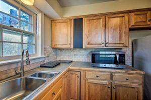 雷丁1 Mi to Reading Pagoda Cozy Apt with Patio Access!的配有木质橱柜、水槽和微波炉的厨房