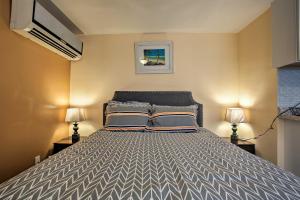a bedroom with a large bed with two lamps at Hip Studio with Patio 1 Mi to Pompano Beach Pier in Pompano Beach