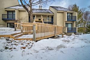 una casa con una valla de madera en la nieve en Townhome on Summit Mtn - Skiers Dream! en Bellaire
