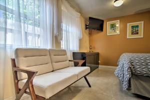 a room with a couch and a bed and a television at Hip Studio with Patio 1 Mi to Pompano Beach Pier in Pompano Beach