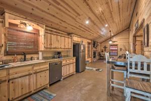 uma grande cozinha com armários de madeira e um frigorífico em Cabin with Hot Tub Near Broken Bow Lake and Hiking em Broken Bow