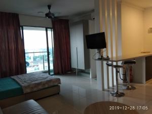 a room with a bed and a desk and a television at hasanah evo studio suites in Kampong Sungai Ramal Dalam