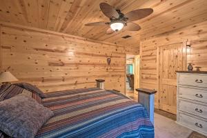 um quarto com uma cama e uma ventoinha de tecto em Cabin with Hot Tub Near Broken Bow Lake and Hiking em Broken Bow