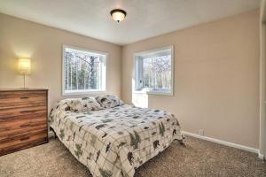 1 dormitorio con 1 cama y 2 ventanas en Peaceful Mountain-View Home - Walk to Kenai Lake!, en Cooper Landing