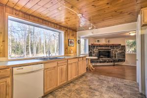 cocina con armarios de madera y chimenea en Peaceful Mountain-View Home - Walk to Kenai Lake!, en Cooper Landing
