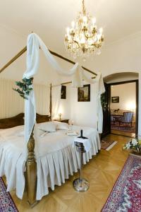 a bedroom with a canopy bed and a chandelier at Hotel Štekl in Hluboká nad Vltavou