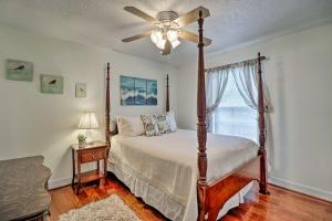 a bedroom with a bed with a ceiling fan and a window at Pet-Friendly Amelia Island Home about 1 Mi to Beach! in Fernandina Beach