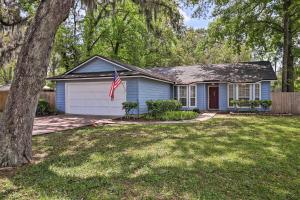 a blue house with a flag in a yard at Pet-Friendly Amelia Island Home about 1 Mi to Beach! in Fernandina Beach