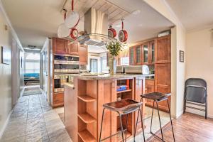 a kitchen with wooden cabinets and a island with stools at Surfside Beach Home with Resort Perks Walk to Beach in Myrtle Beach