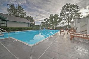a swimming pool with a bench next to a house at Walk-In Condo on Golf Course with Pool Walk to Strip in Branson